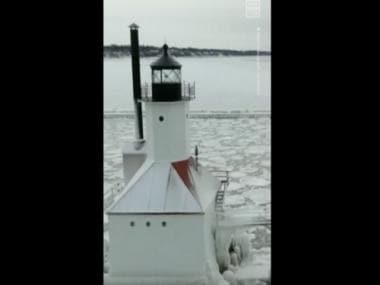 Watch: Lighthouse and surrounding pier in Lake Michigan shrouded in ice following blizzard